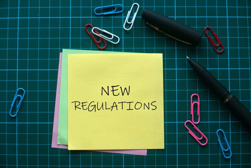 Note with New Regulations written on it. Concept of mortgage reform.