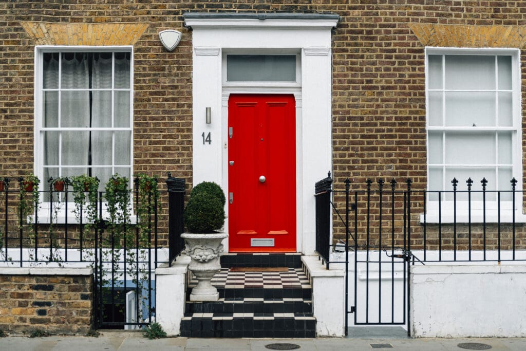 Home exterior. Bright red front door with tiled steps. Concept of curb appeal