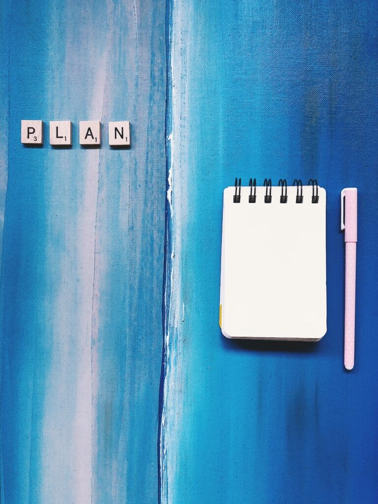 How to Overcome Bad Work Habits and Boost Productivity. Notebook and pen with the word PLAN. Concept of planning