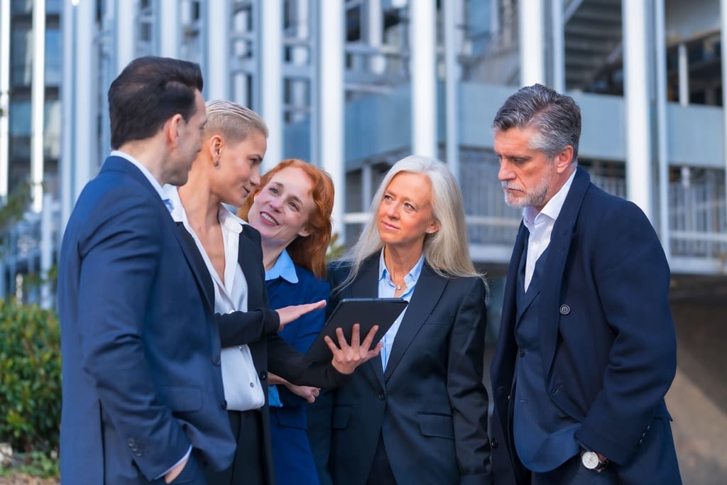 Collaborative Business Meeting of Senior Executives with Digital Tablet in Hand - Real-Estate-Leads How Real Estate Agents Can Boost Feedback: Collaborate with Professionals