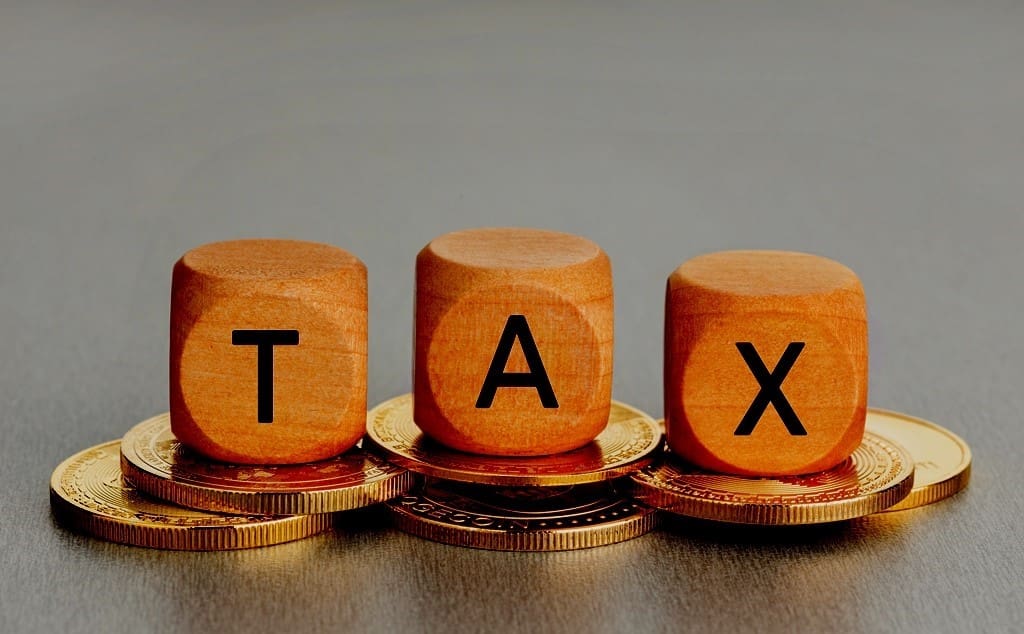 Cryptocurrency TAX concept Coins and wooden blocks with text Copy space - Real-Estate-Leads Unlocking Lucrative Investment Opportunities in REITs: Tax Advantages