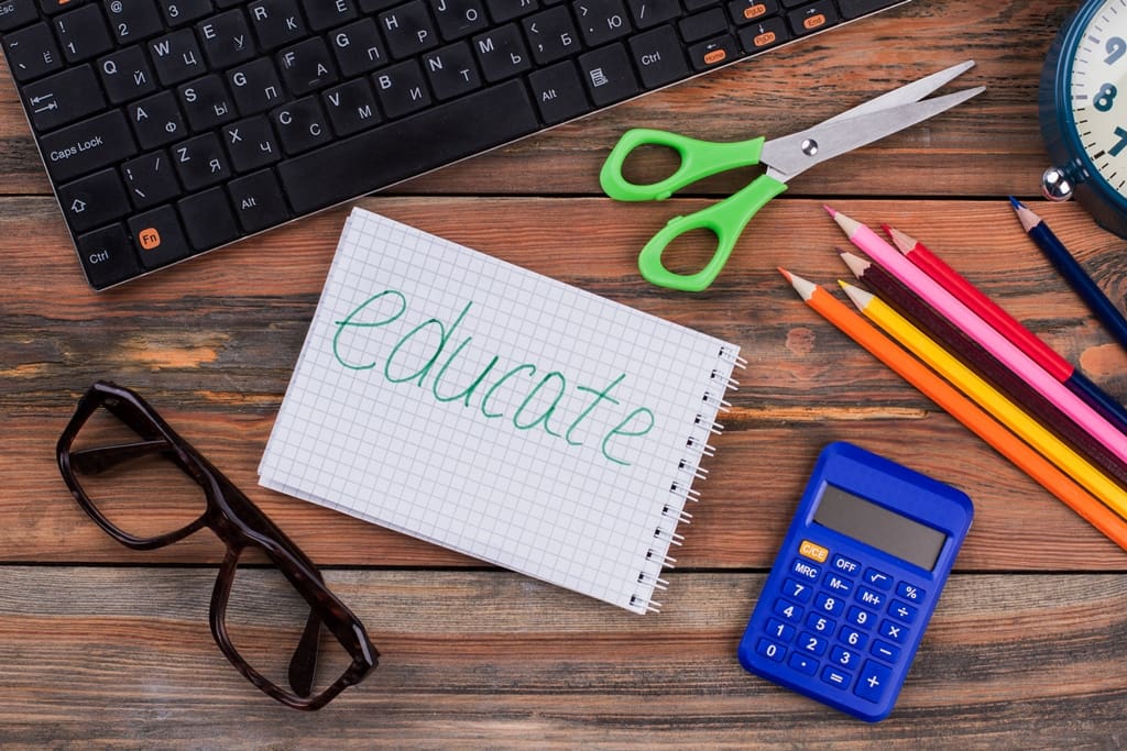 Educate accessories on a wooden desk Flat lay top view - Real-Estate-Leads How to Promote Investment Opportunities to Your Real Estate Clients: Educate Your Clients