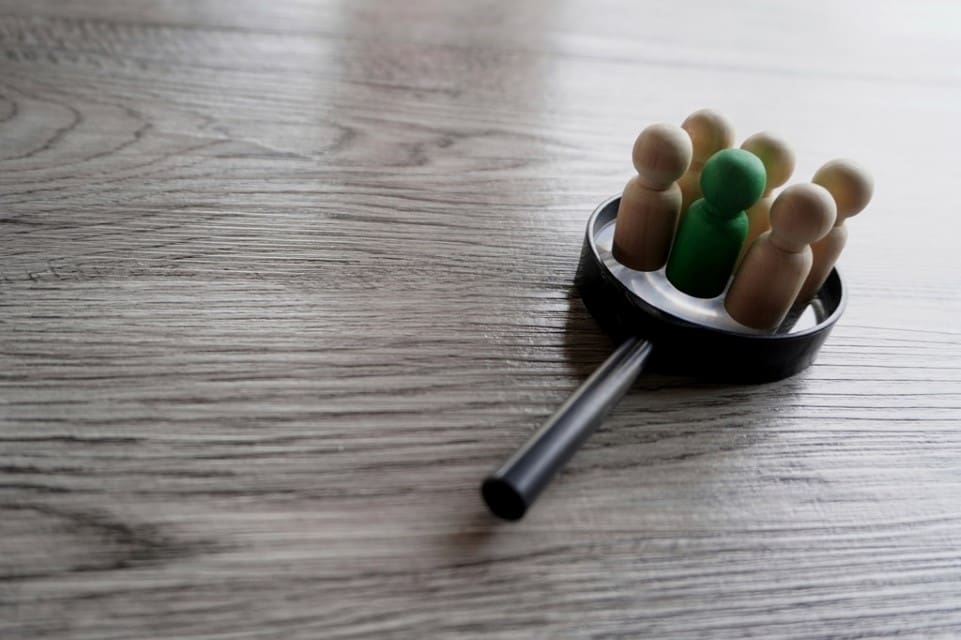wooden-dolls-on-top-of-magnifying-glass-2023-08-01-00-20-24-utc - Real-Estate-Leads How to Effectively Segment Real Estate Markets: Identify Segments